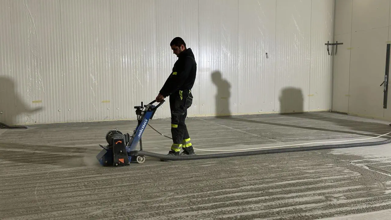 Grinding a concrete floor with a trowel machine and laser level