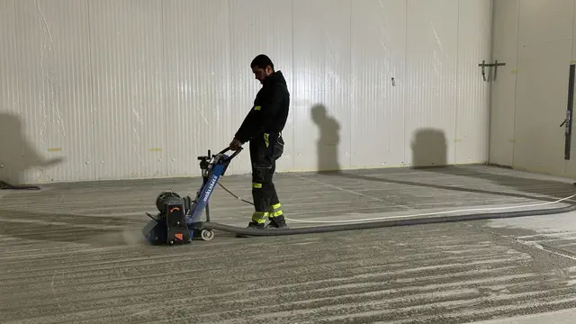 Grinding a concrete floor with a trowel machine and laser level